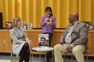 Student asking author a question at a school assembly