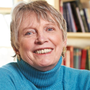 Headshot of Lois Lowry smiling into camera, wearing a blue sweater. She is a senior white woman with short grey hair.