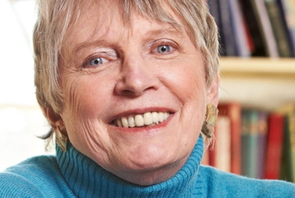 Headshot of Lois Lowry smiling into camera, wearing a blue sweater. She is a senior white woman with short grey hair.